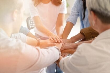 Grup-de-oameni-cu-mainile-intinse-in-semn-de-suport