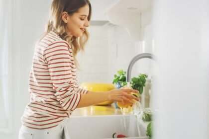 femeie-spala-vase-apa-calda