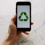 mana-unui-barbat-tinand-un-telefon-cu-semnul-reciclarii-pe-ecran