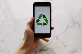 mana-unui-barbat-tinand-un-telefon-cu-semnul-reciclarii-pe-ecran