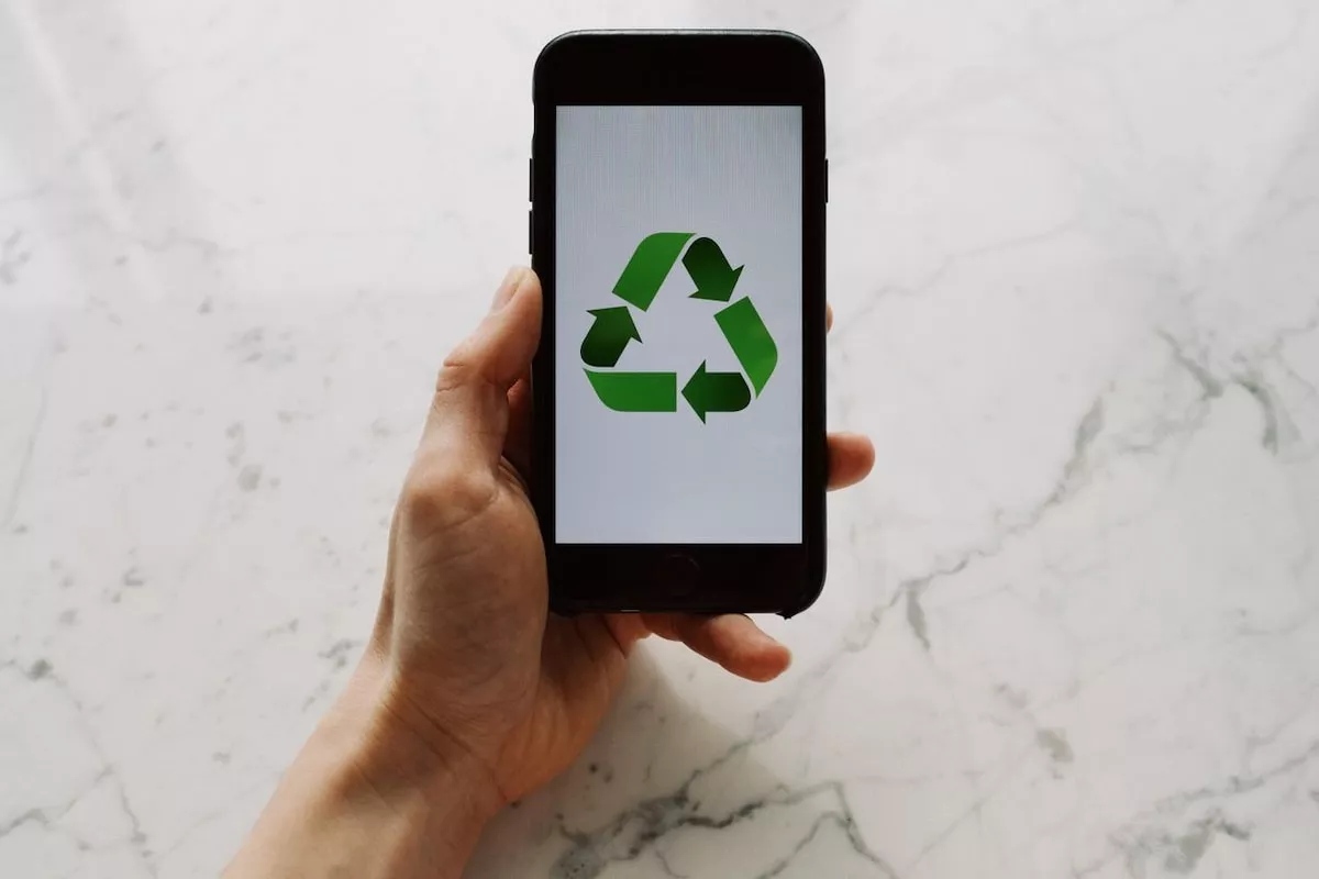 mana-unui-barbat-tinand-un-telefon-cu-semnul-reciclarii-pe-ecran